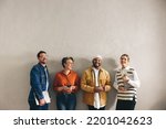 Small photo of Cheerful businesspeople smiling happily while waiting in line for an interview. Group of shortlisted job applicants holding different digital devices in a modern office.