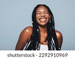 Small photo of Black woman with body piercings smiling in a studio. Happy young woman feeling confident in herself.