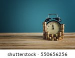 Small photo of concept of Opportunity cost time is money clock and coins on wooden table