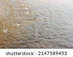 Small photo of The surface of the water is perturbed by the fountain jets. Splashes on the water. Abstract background.