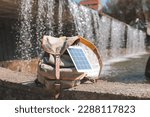 Small photo of Portable solar panel.Traveler uses green energy to charge gadgets.Eco crisis,eo friendly,sustainable energy,solar panel energy transition,sustainablelifestyle