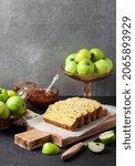 Small photo of Sliced apple and coconut oaf cake on wooden cutting board on dark background. Copy space