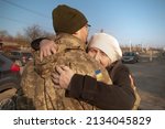 Small photo of Elderly mother says goodbye to her military son. Mom hugs a Ukrainian soldier. Militarization. Ukrainian defender says goodbye to his family. Mobilization of Ukrainian men. War of Ukraine and Russia