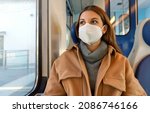 Small photo of Travel safely on public transport. Young woman with KN95 FFP2 face mask looking through train window. Commuter passenger with protective mask travels sitting on train.