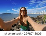 Trendy millennial girl having fun takes self portrait on summer vacation in Balneario Camboriu, Brazil