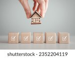 Small photo of Home buying checklist and hire a real estate, Business and financial, Refinance, House purchase, Loan, Tax, Mortgage, Asset management, Property investment. Hand holding house on complete check mark.