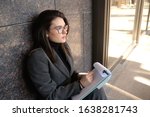 Gourgeous professional woman in business attire writing in clip bord