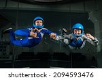 Small photo of A man and a woman enjoy flying together in a wind tunnel. Free fall simulator