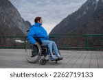 Small photo of A woman in a wheelchair on a point view admires the high mountains. Thrust to life.