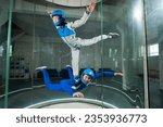 Small photo of A man and a woman enjoy flying together in a wind tunnel. Free fall simulator