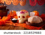 Small photo of Pan de Muerto with sugar skull and Cempasuchil flowers or Marigold and Papel Picado. Decoration traditionally used in altars for the celebration of the day of the dead in Mexico