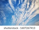 Small photo of Blue sky background with tiny stratus cirrus striped clouds. Clearing day and Good windy weather