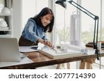 Selective focus, Asian female architect or engineer Currently considering materials for designing modern condominiums. Asian female architect or engineer Sit and analyze, design projects in the office