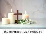 Small photo of Wooden cross, snowdrops flowers and candles on table, abstract background. Religious church holiday. symbol of faith in God, Christianity Feast, Easter, Palm Sunday, Lent