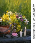 Small photo of wiccan Goddess Candlestick, Copper witch cauldron with flowers, magic things, candles on meadow, natural background. herb lore, occult. esoteric ritual, witchcraft, spiritual practice.
