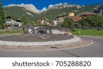 Small photo of Small community of Vigo di Fassa in Val (valley) di Fassa-August 13, 2017: The turnabout at entrance of the village with Catinaccio/Rosengarten mountain massif in background, Dolomites, Italy