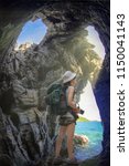 Small photo of young woman tourist lost and misguided in the cave of the sea, lost way and enjoy the nature of cave
