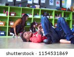 Small photo of A stubborn intractable and naughty boy kids in classroom at kindergarten pre school anti learning gives headache to woman teacher. Uncontrolled if boys kids behaviour