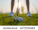 Small photo of golf ball laying in the rough o grass meadow out of the fairway, being hit by the golfer revert to the fairway, difficult time of life find success forward