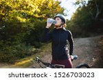 Female cyclist drinking water from bottle