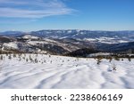 Snowy panorama at Silesian Beskid mountains range on european Bialy Krzyz in Poland, clear blue sky in 2022 warm sunny winter day on February.