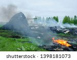 The crash of a transport plane outside the city in the countryside. A charred plane after a crash.