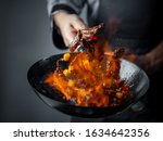 Wok pan cooking asian food with fire flames  and flaming meat and vegetables. Hotel professional service food photo concept. Cooking recipe by chef menu.