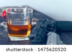 Glass of whiskey and gun...