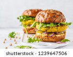Vegan chickpeas burgers with arugula, pickled cucumbers and hummus. Plant based diet concept.