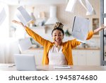 A crazy excited happy young african american woman, business lady, manager or freelancer working remotely at home, enjoying career growth or good deal, gesturing with hands, scattering documents