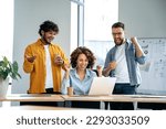 Cheerful group of motivated successful multiracial business people, working together on a project in a modern office, using laptop, discussing ideas, brainstorming, rejoicing in success, smile