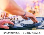 Small photo of Dj mixing at beach party festival with people dancing in the background - Deejay playing music mixer audio outdoor - Concept of summer events and club outdoor