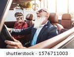 Small photo of Happy senior couple having fun on new convertible car - Mature people enjoying time together during road trip vacation - Elderly lifestyle and travel transportation concept