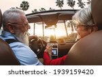 Small photo of Happy senior couple having fun driving on new convertible car - Mature people enjoying time together during road trip tour vacation - Elderly lifestyle and travel culture transportation concept