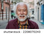 Portrait of happy Asian senior man smiling in front of camera