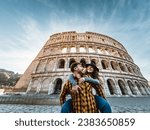Happy young romantic couple having fun together in Rome Colosseum - Love relationship and travel lifestyle concept