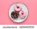 Classic chocolate, strawberry donut on white round plate with black peas isolated on pink background Flat lat lay Top View Knolling Unhealthy and tasty food concept Holiday card