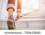 Young adult woman walking up the stairs with sun sport background.