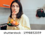 Woman Eating Macarons Feeling Guilty and Hiding. Adult person with sugar addiction hiding her alimentary habits over indulging because of stress
