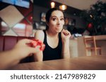 Small photo of Surprised Girlfriend Reluctant to Accept a Small Gift from her Date. Woman reacting negatively to present she received for being cheap and bad