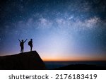 Small photo of Silhouette of two young man standing, open arms and watched the star, milky way and night sky on top of the mountain. They enjoyed traveling and was successful when he reached the summit.