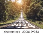 New year 2024 or straight forward concept. Text 2024, 2025, 2026 written on the road in the middle of asphalt road with at sunset. Concept of planning, goal, challenge, new year resolution.
