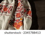 Small photo of Ukrainian clothes embroidered shirt. Red orange and black threads background. Vyshyvanka is a symbol of Ukraine. Embroidery cross stitching. National Ukrainian stitch. Traditional clothing symbol.