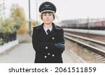 Small photo of European or American train conductor is on his duty on a platform and other trains. Railway, steam trains .Train controller on the train, near a locomotive