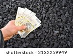 Polish currency showed on coal of mine deposit mineral resources background whose prices increase during high inflation in Poland