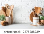 Kitchen utensils background with a blank space for a text and white brick background, home kitchen decor concept with kitchen tools, front view