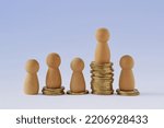Small photo of Pawns on stacks of coins - Concept of economic inequality