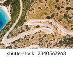 Windy road along coast of Aegean sea, aerial top down view