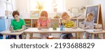 Small photo of Cute children sitting in the classroom and wring a lesson. Concept of back to school.