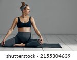 Full Body Portrait Of Pregnant Woman Doing Yoga On Exercise Mat. Isolated on gray background